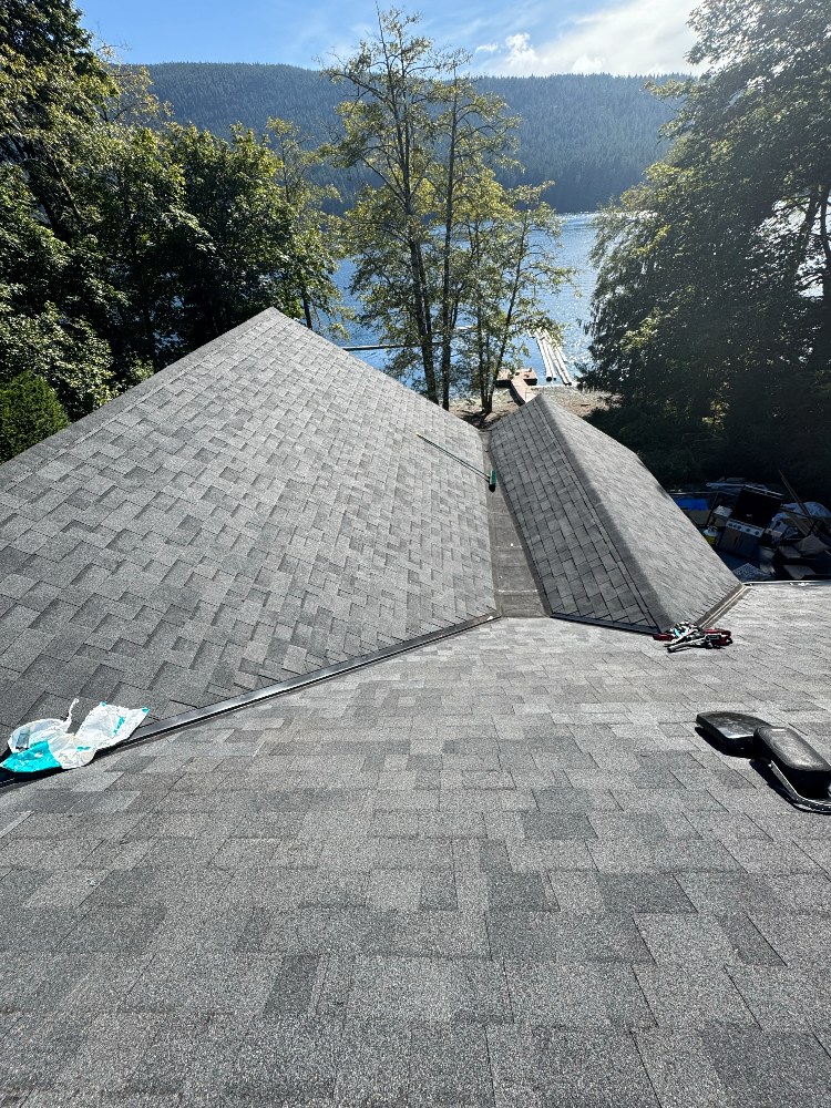 Roofing crew installing shingles on a home overlooking a Vancouver Island inlet